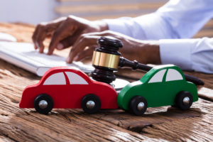 toy cars in accident with gavel and lawyer in the background